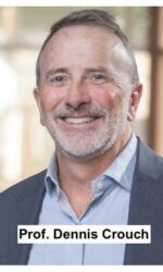 Smiling middle-aged man in a blazer and light blue shirt, wearing a name badge that reads a person’s title.